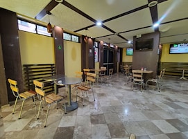 Un restaurant avec un sol à carreaux, des tables rondes et des chaises en bois.