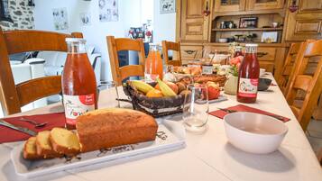 Una mesa de desayuno con pan, frutas y salsas.