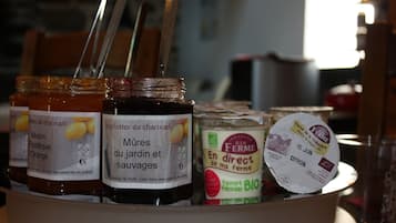 A variety of food products including jars of preserves and a container of yogurt.