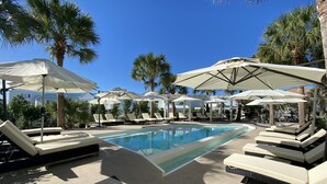 Un espace piscine équipé de chaises longues et de parasols.