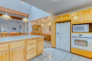 Enjoy cooking in this well-equipped kitchen with a central island, appliances, and a dining area.