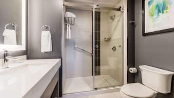 Une salle de bain moderne avec une douche à parois de verre, un lavabo blanc et des toilettes.