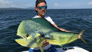 A person holding a large fish on a boat.