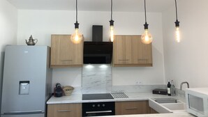 A modern kitchen with wooden cabinets, a stainless steel refrigerator, a built-in oven, and a microwave. - Villa in Dieulefit in Drome Provençale with views of nature and mountains (Dieulefit)