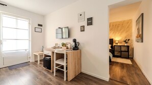 Une cuisine moderne avec un plan de travail en bois, un four encastré et un téléviseur fixé au mur.