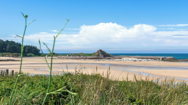 A beach with a rocky outcrop, clear skies, and calm waters. - Homerez - House in Plurien (Plurien)