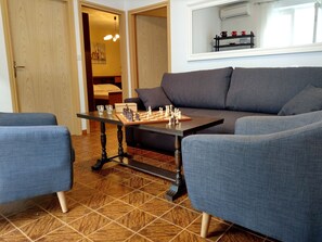 A living room with a chessboard on a table, a sofa, and a coffee table.