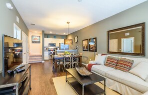 Relax in this stylish living space with a comfortable sofa, dining table, and fully equipped kitchen.