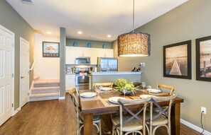 A dining area with a wooden table, chairs, and a hanging light fixture. - Top Pick! Beautiful & Cozy 3bd Home, Gated Community, 10 Minutes from Disney (Kissimmee)