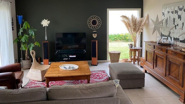 A modern living room with a flat-screen TV, a wooden coffee table, a sofa, a cabinet, and a large window offering a view of the outdoors. - 10-minute walk to the sea for 2 to 6 people (Le Relecq-Kerhuon)
