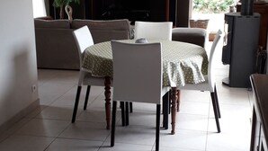 A dining area with a table and chairs, a sofa, a television, and a decorative wall piece. - 10-minute walk to the sea for 2 to 6 people (Le Relecq-Kerhuon)