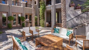 A courtyard with outdoor seating, stone pillars, and a staircase. - Hacienda near the Las Vegas Strip (Las Vegas Nevada)