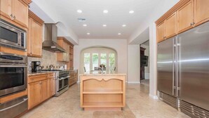 A modern kitchen with wooden cabinets, stainless steel appliances, and a central island. - Hacienda near the Las Vegas Strip (Las Vegas Nevada)