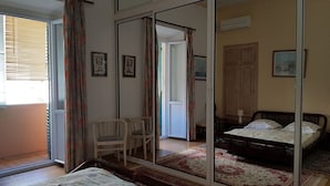 Une chambre à coucher avec un grand miroir, un lit, une chaise et une armoire.