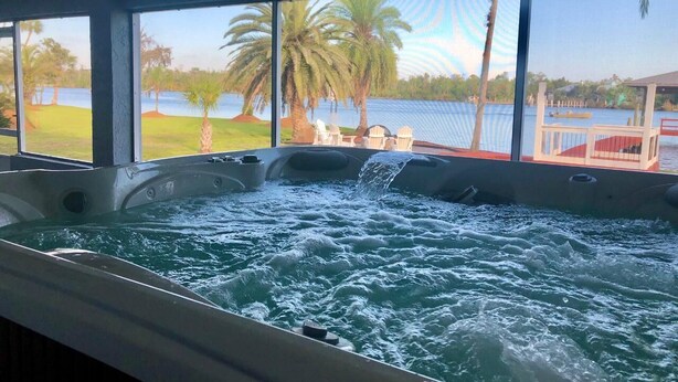 Ein Whirlpool mit Blick auf einen See und Palmen.