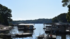 A calm lake with docks and boats. - Lakefront Retreat Sleeps 19 • Hot Tub + Paddle Boards • Family & Group Favorite! (Eldon)