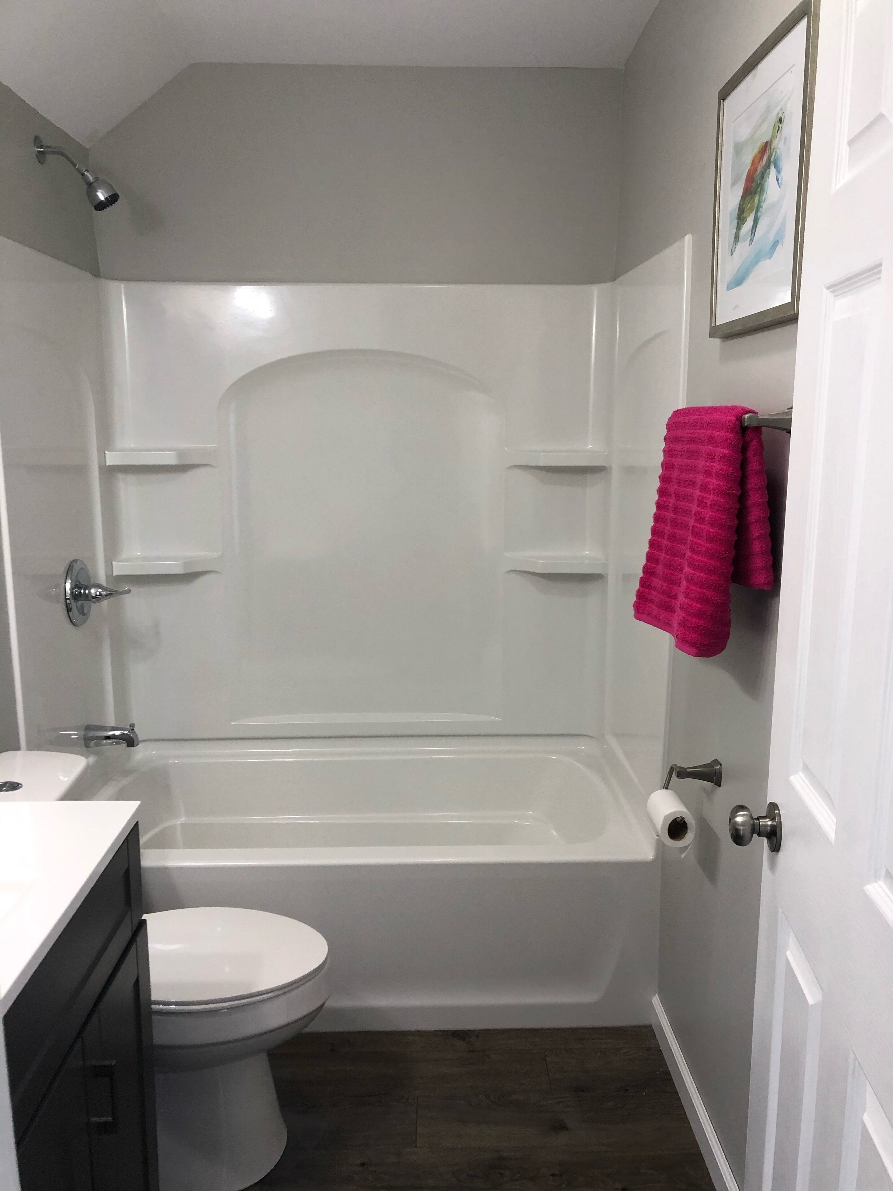 Un bagno con una vasca da bagno bianca, un water, un lavandino e una doccetta.
