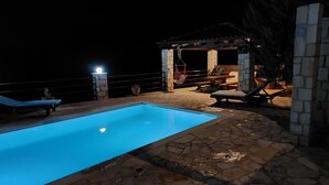 A swimming pool with stone tiles, lounge chairs, and a wooden pergola with hanging chairs. - Little House on the Prairie - Private Pool (Chania)