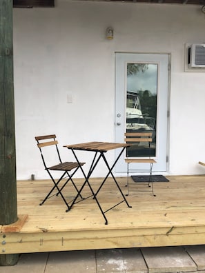 Situated on a deck, this outdoor seating area offers a simple table and two chairs for relaxation.