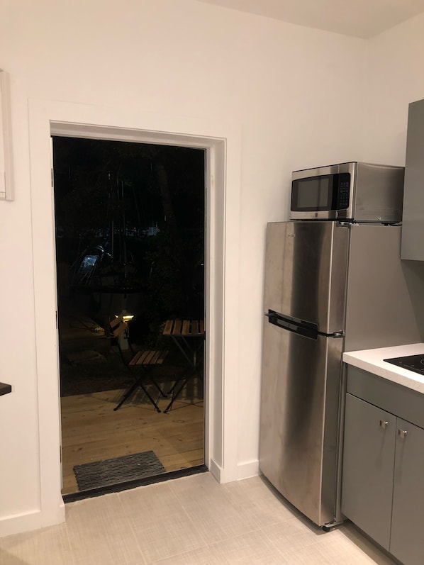 Kitchen area with refrigerator, microwave, and sliding door to outdoor space.