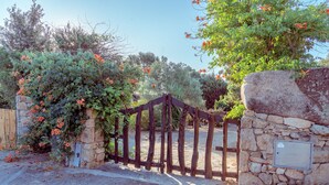 A stone wall with a metal plate, a wooden gate, and a stone wall with a metal plate.