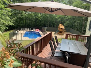 Relax and entertain in this spacious backyard with a deck, seating area, and pool.