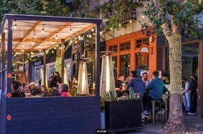 An outdoor dining area with string lights, a covered seating area, and a tree decorated with lights. - Walkable Urban Retreat - 2 En-Suite Baths - Near Top Dining & Shops & Hotspots! (SF)