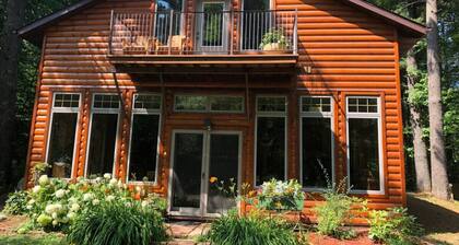 Rauhallinen metsäinen asetusviitti, jossa on makuuhuone, kylpyamme ja oleskelutila.