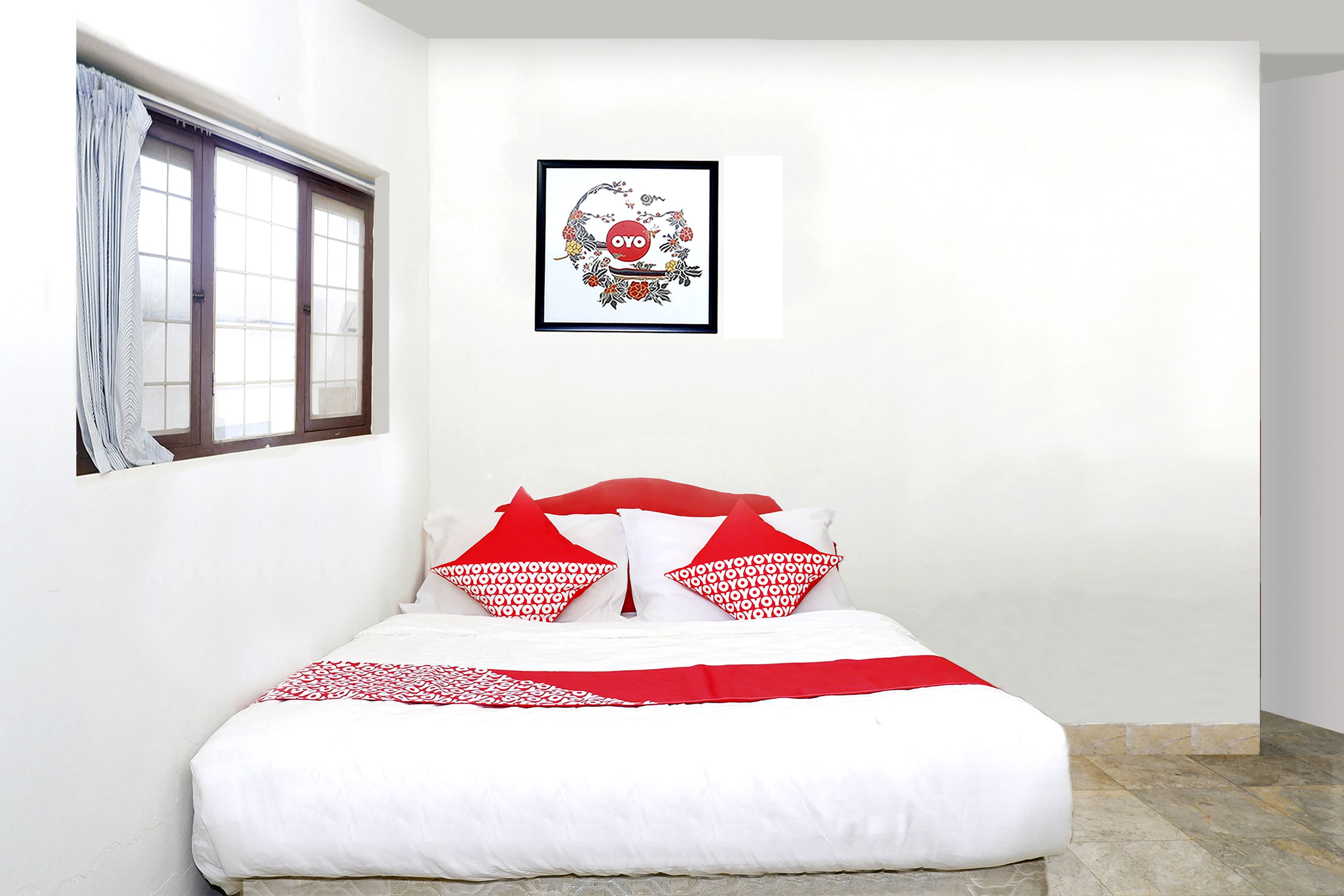 Un dormitorio con cama, paredes blancas, una ventana con cortinas e imagen enmarcada en la pared.