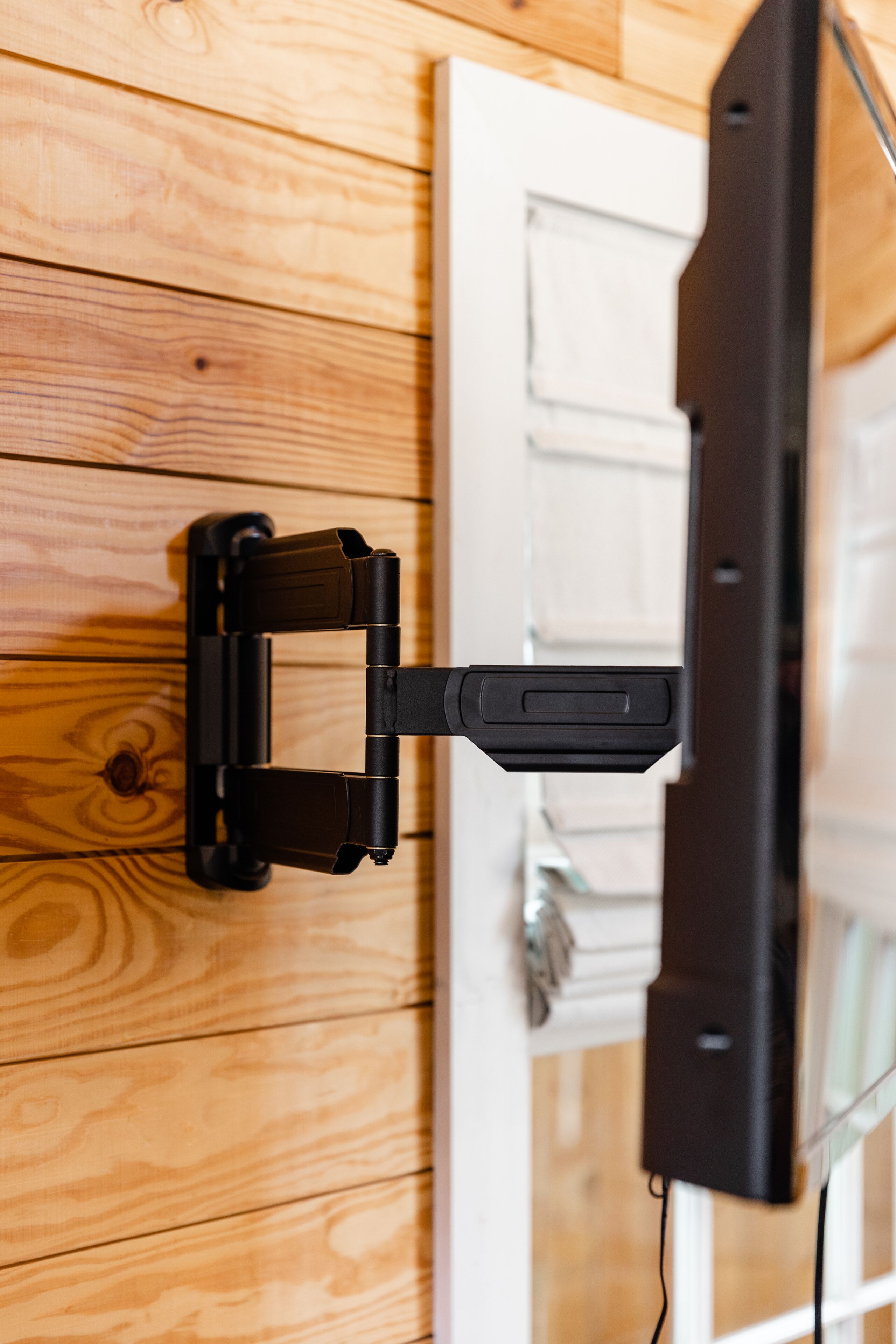 A wall-mounted television on a wooden panel wall.