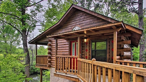 Una cabaña de madera con terraza, puerta de cristal y ventana.