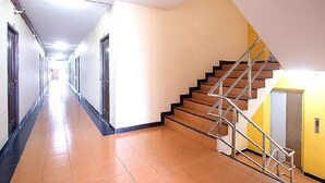 Un pasillo largo y estrecho con una escalera a la derecha.