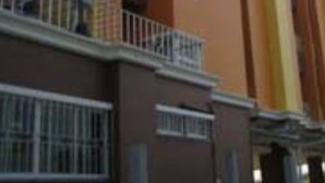 Un edificio de varios pisos con techo plano, balcones y fachada de ladrillo.