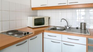 A kitchen with white cabinets, a microwave, a sink, and a stove. - Casa Itzuli by Interhome (Bayonne)