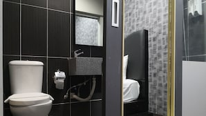 Une salle de bain moderne équipée de toilettes, d’un lavabo et d’un espace douche.