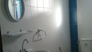 Une salle de bain avec un lavabo, un miroir et des toilettes.
