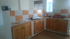 Une cuisine avec des meubles de rangement en bois, un évier et une cuisinière.