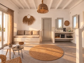 Un salon moderne avec un canapé, un tapis rond tissé et un coin repas comprenant une table et des chaises.