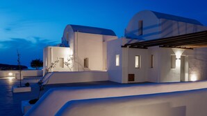 A modern white building with a flat roof and a covered outdoor area. - Bianco Diverso Suites (Santorini)