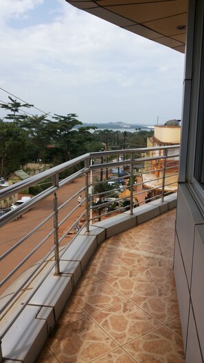 Un balcon donnant sur une rue et des immeubles.
