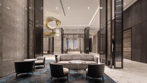 A modern lobby with a grey sofa, round tables, and black chairs. - Lakeshore Hotel Tainan (Tainan)