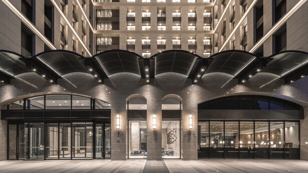 A modern hotel entrance with a glass facade, arched entryways, and a central atrium with a ceiling design. - Lakeshore Hotel Tainan (Tainan)