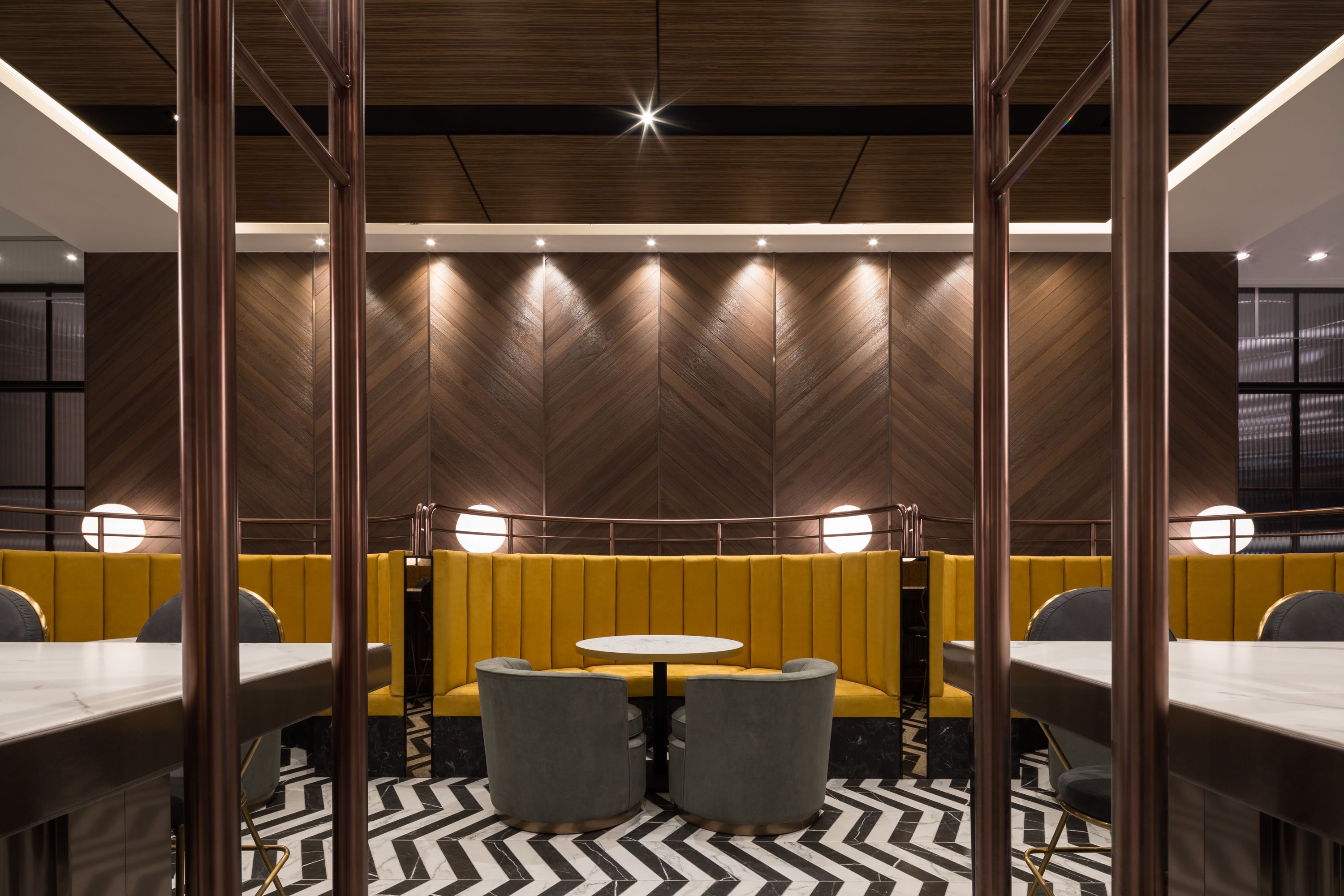 A modern interior with a central seating area, high ceilings, and a patterned floor.