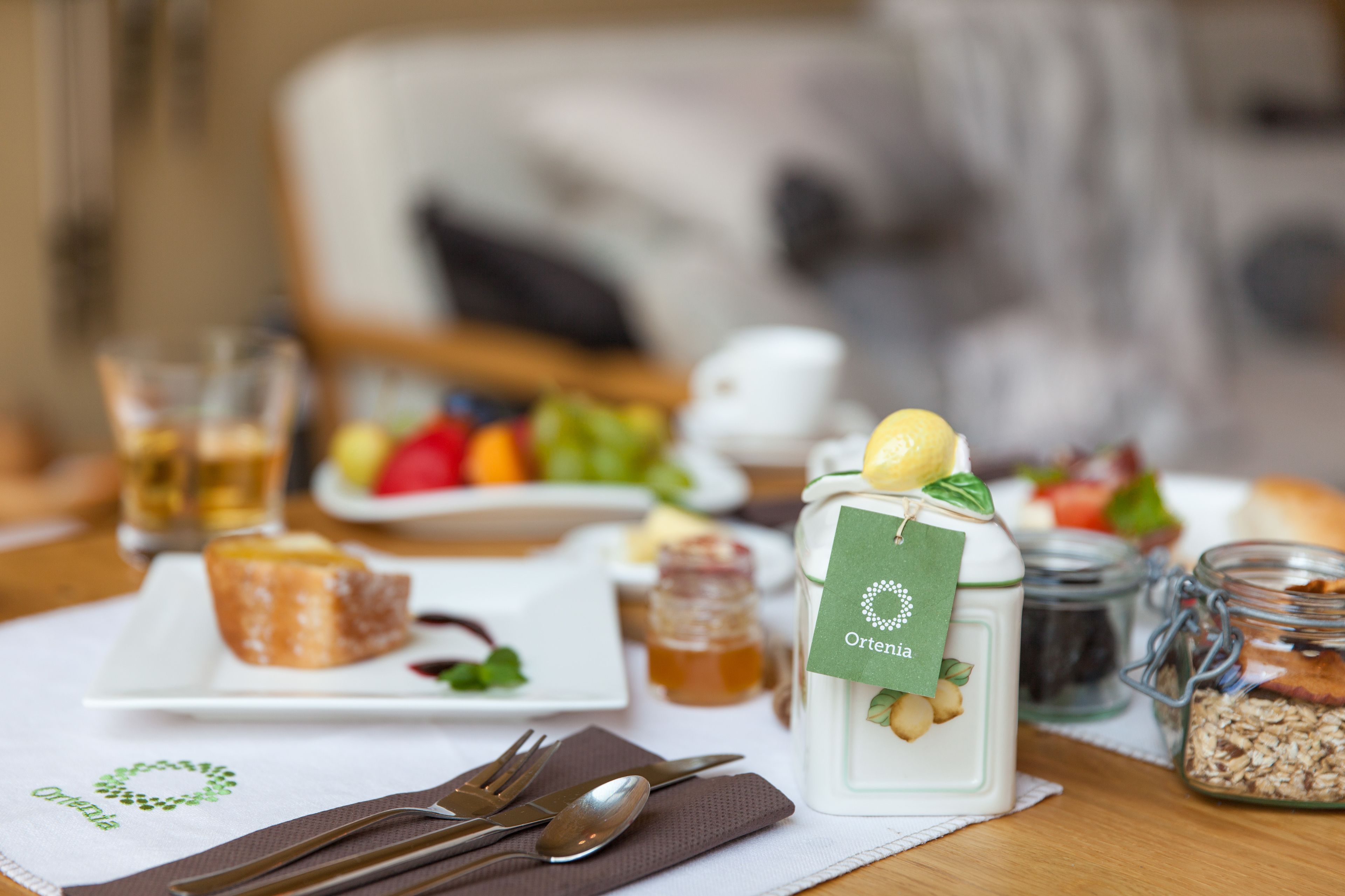 A dining table with a plate of food, a jar of nuts, and a jar of honey.