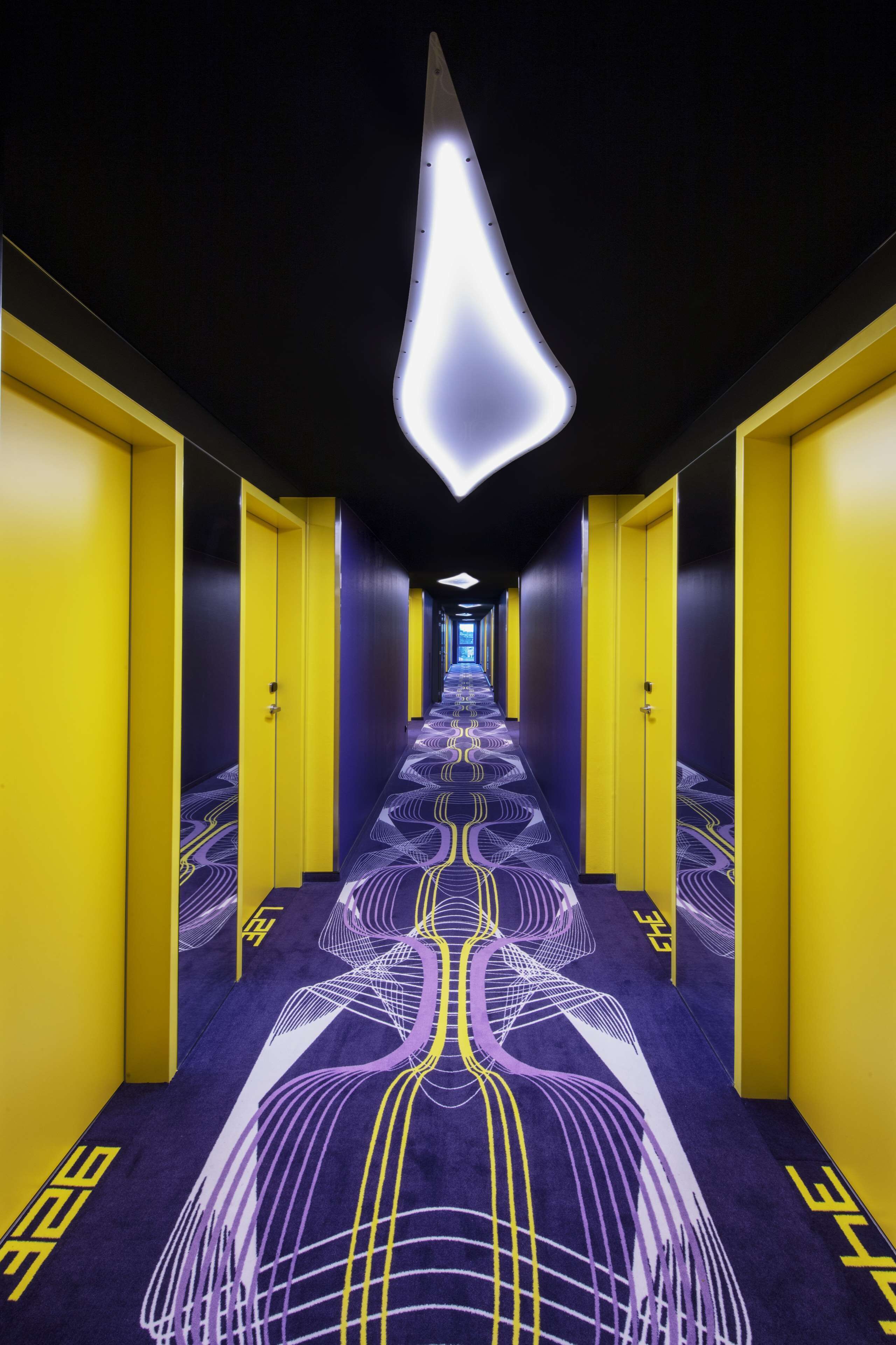 A hallway with yellow doors and a patterned carpet.
