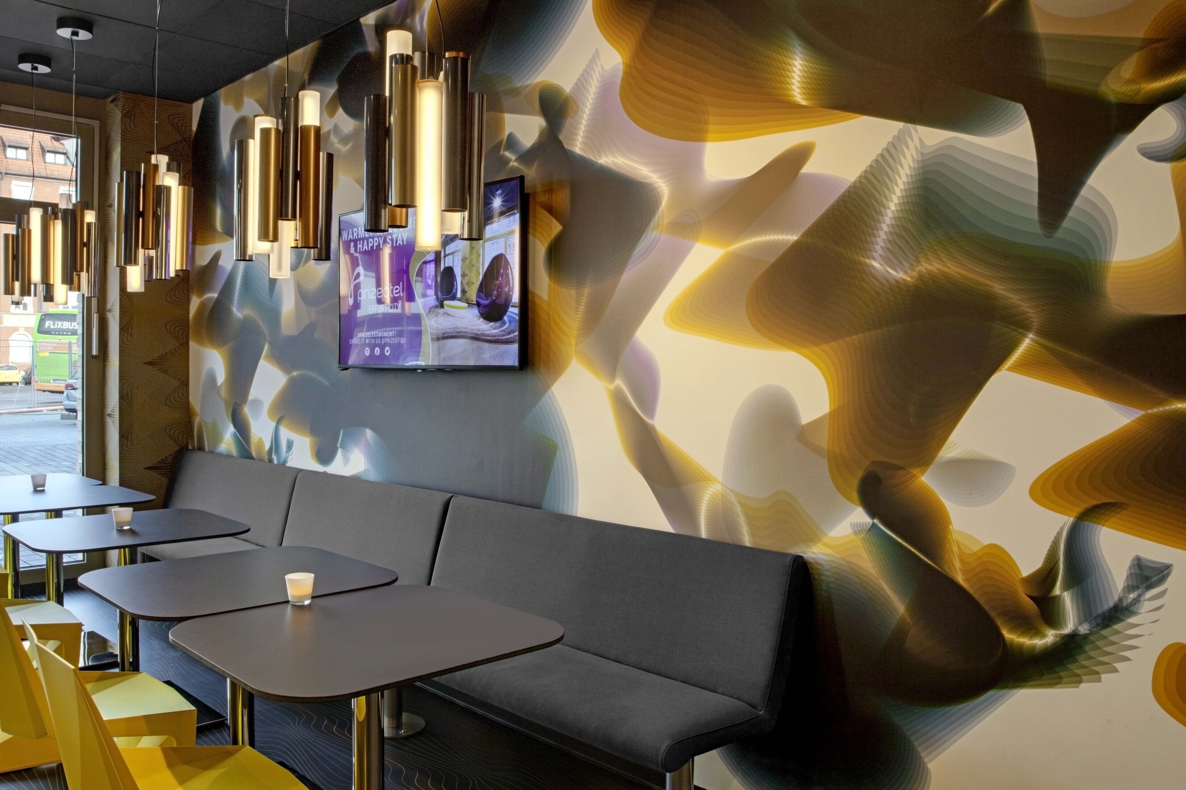 A modern interior with a sofa, tables, and pendant lighting.