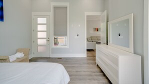 Ein modernes Schlafzimmer mit einem großen Bett, einem begehbaren Kleiderschrank und einem Badezimmer mit Fenster.