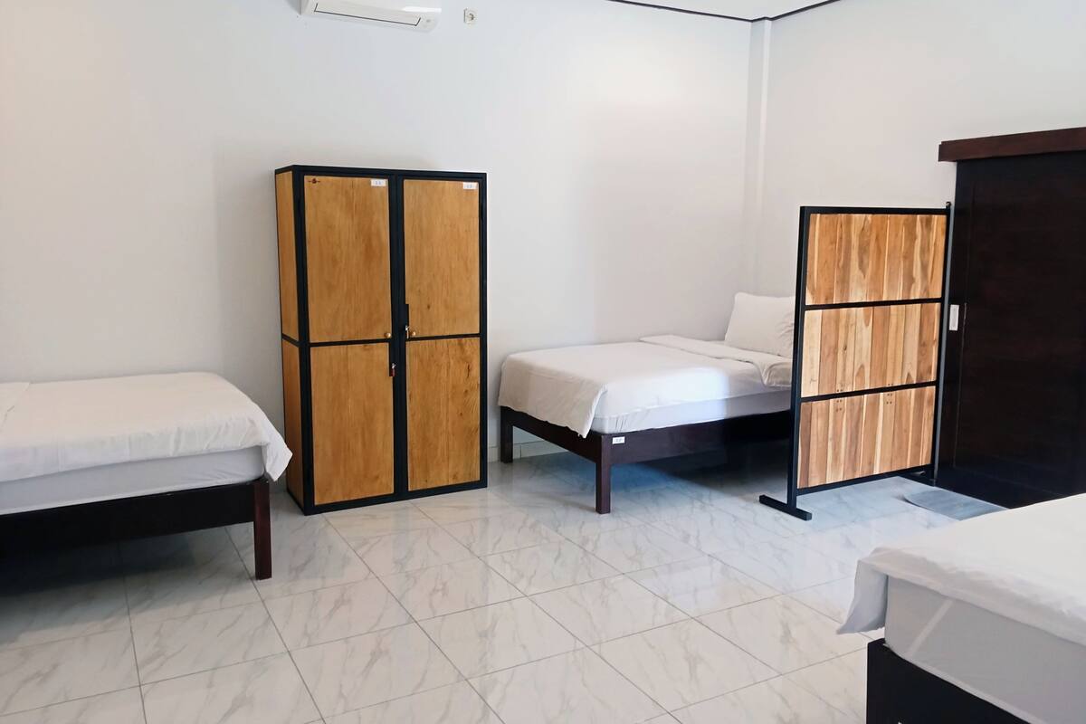 A hotel room with a bed, a wardrobe, and a desk.