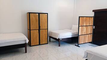 Una habitación de hotel con cama, armario y escritorio.
