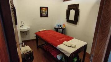 Cozy retreat with a single bed, compact table, and wall-mounted sink.